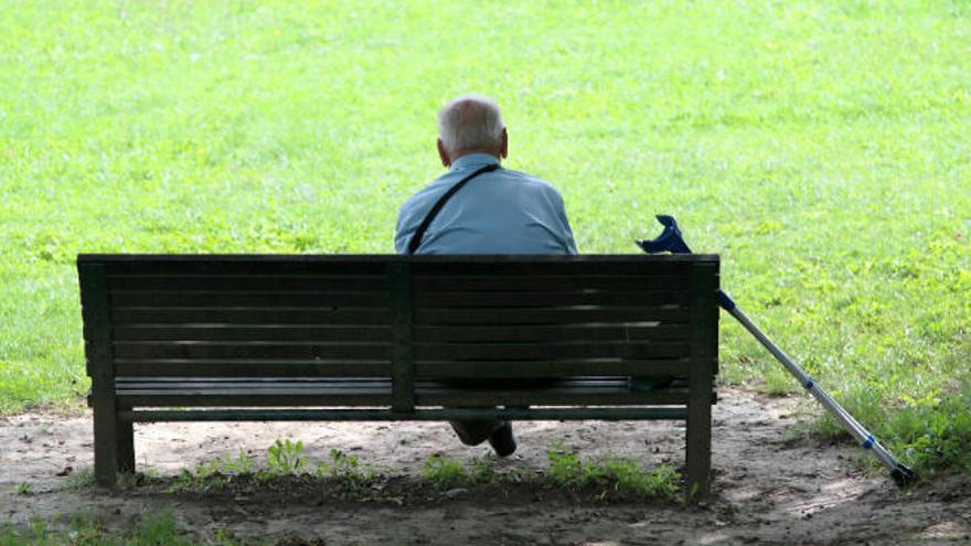 Un hombre solo sentado en un banco.