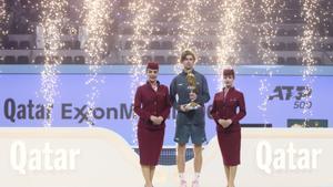 Winner Russias Andrey Rublev celebrates with the trophy after the final match of the Qatar Open tennis tournament against Britains Jack Draper in Doha, Qatar, Saturday, Feb. 22, 2025. (AP Photo/Hussein Sayed)