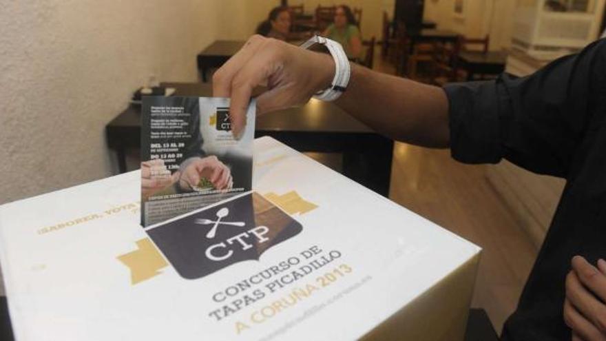 Un participante del Concurso de Tapas Picadillo emite su voto en una de las urnas que hay en los locales. / víctor echave