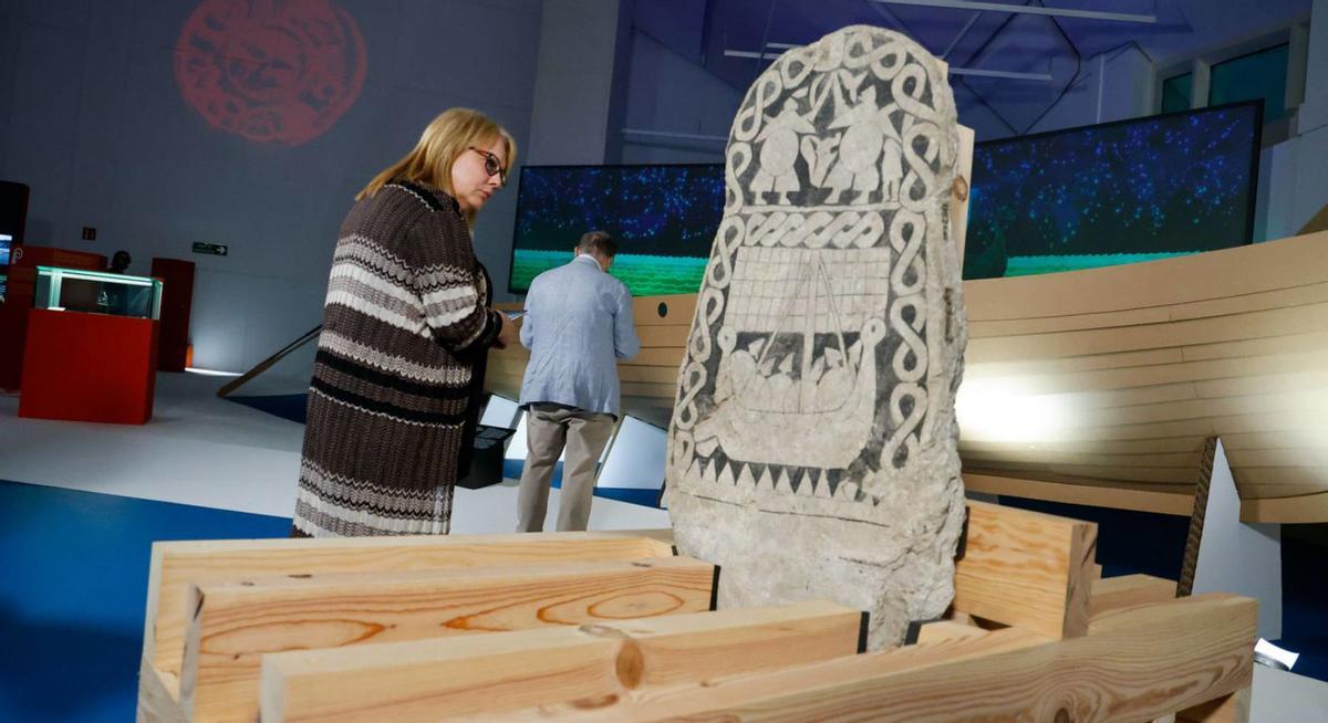 Una visitante observa una piedra rúnica de la muestra de vikingos en el Museo Centro Gaiás.   | // JESÚS PRIETO 