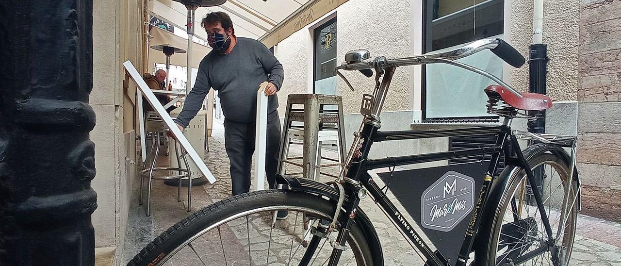 Guillermo Sordo recoge las banquetas de su taberna en Llanes. | E. S. R.