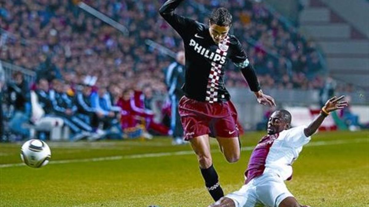 Afellay trata de salvar la entrada de Eyong Enoh, el sábado en el Amsterdam Arena, en el 0-0 entre el Ajax y el PSV.
