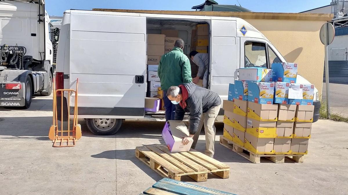 Voluntarios recogiendo alimentos para realizar el posterior reparto de los lotes en el barrio.