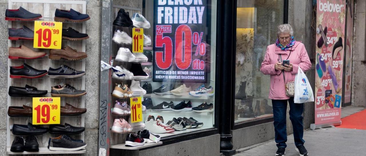 Una mujer pasa por delante de una tienda con descuentos.