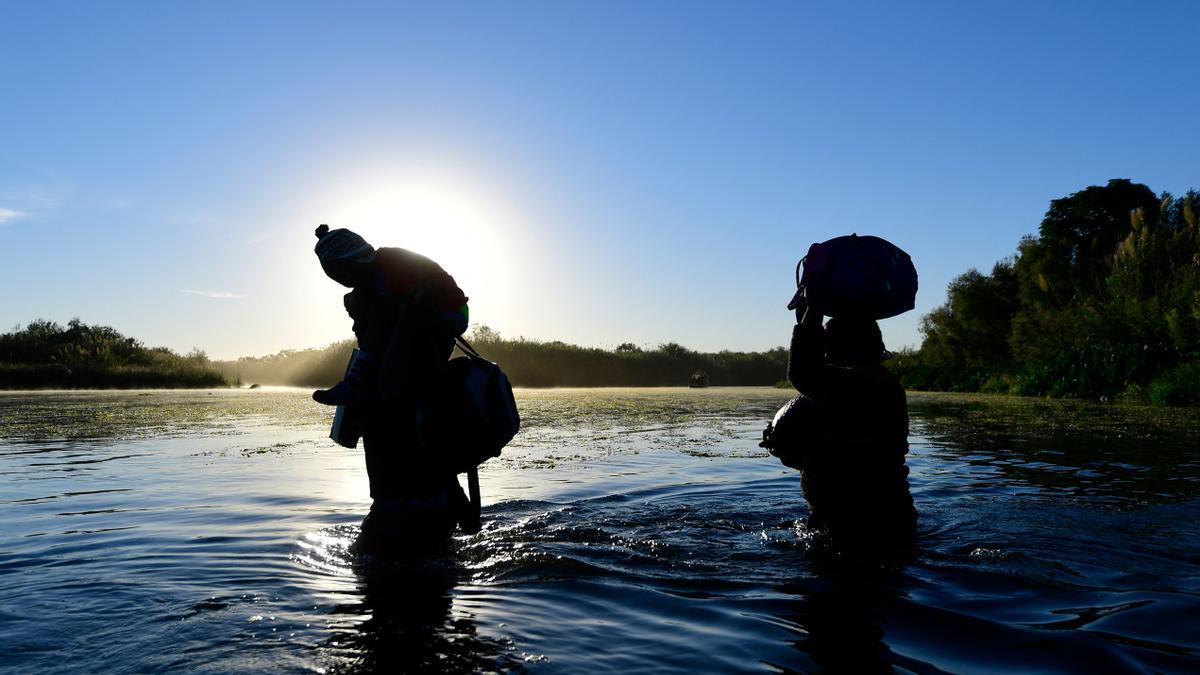 Dos migrantes haitianos cruzan el Río Grande hacia la rivera de EEUU, este jueves.