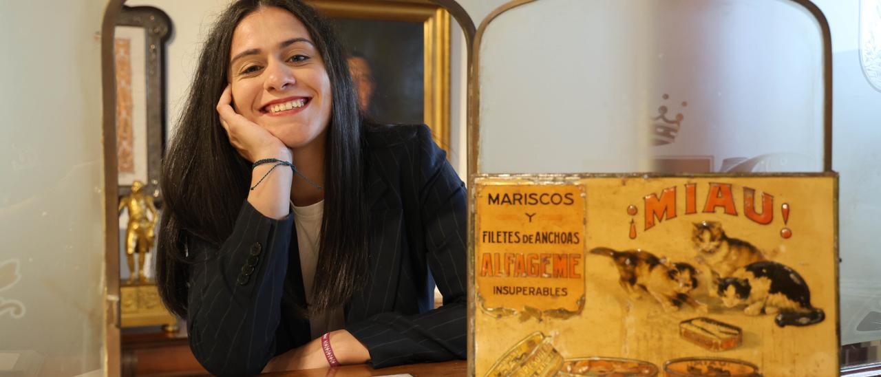 La investigadora Mónica Carballal en el Museo Anfaco con una publicidad de la conservera Alfageme.