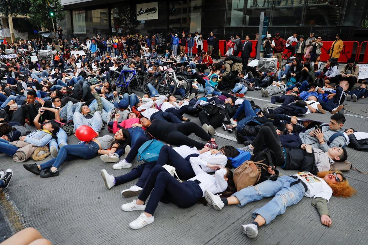 Demonstrators lie on the ground during a protest as a national strike continues in Bogota, Colombia November 26, 2019. REUTERS/Carlos Jasso