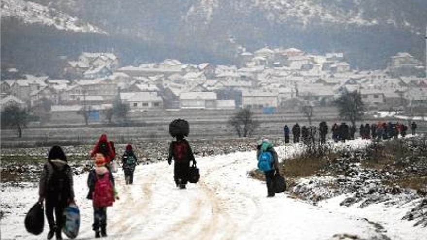 Desenes d&#039;immigrants es desplacen per un camí nevat a Macedònia.