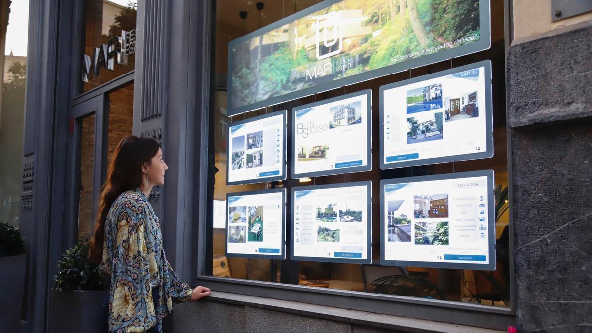 Una mujer observa los precios de una inmobiliaria en Córdoba.