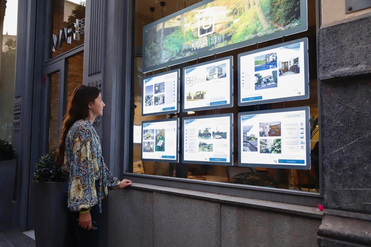 Una mujer observa los precios de una inmobiliaria en Córdoba.