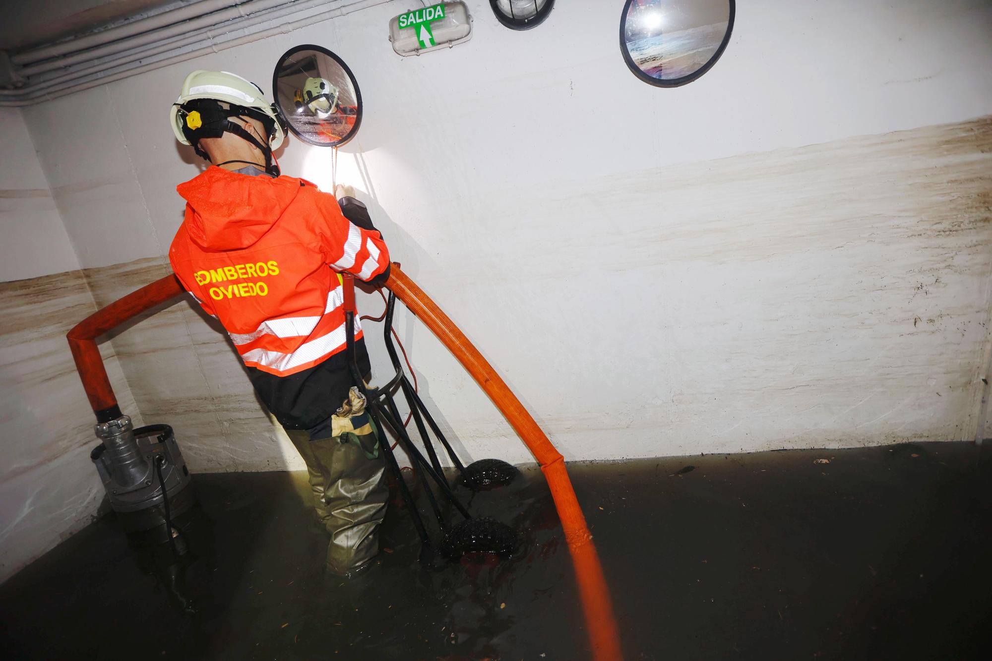 Bomberos interviniendo en garajes inundados de Oviedo.