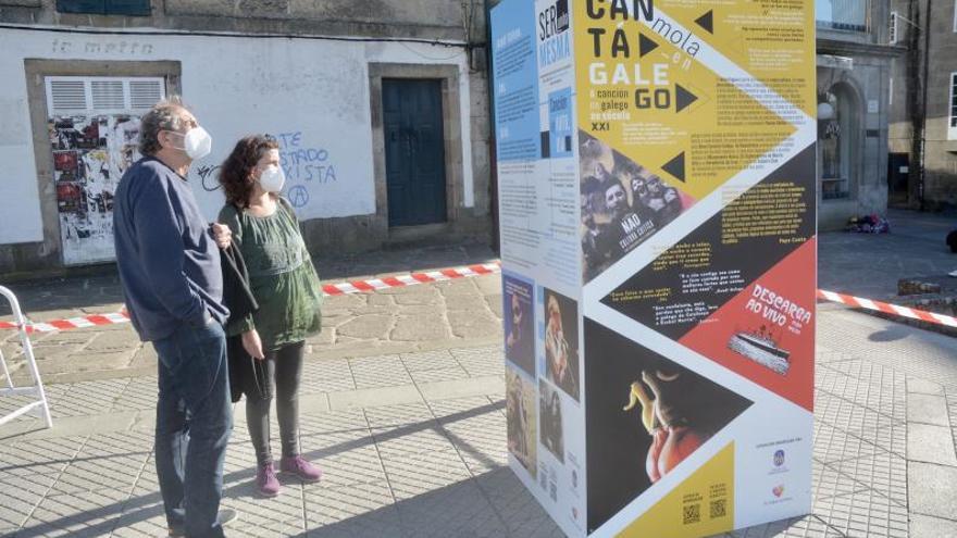 Espectadores da exposición “Cantámola en galego”, inaugurada onte na praza de Ourense.   | // RAFA VÁZQUEZ