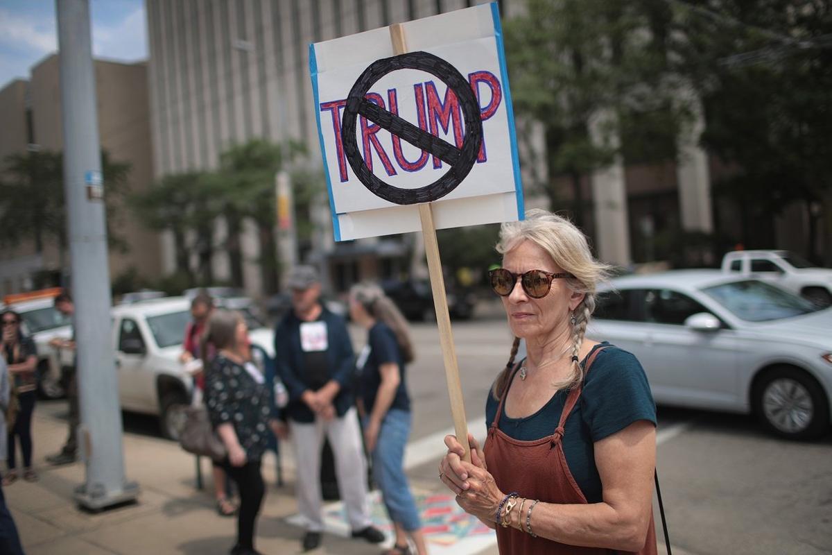 DAYTON, OHIO - AUGUST 06: Demonstrators outside of the Dayton City Hall protest a planned visit of President Donald Trump on August 06, 2019 in Dayton, Ohio. Trump is scheduled to visit the city on Wednesday as residents recover from Sunday Morning’s mass shooting in the Oregon District. Nine people were killed and another 27 injured when a gunman identified as 24-year-old Connor Betts opened fire with a AR-15 style rifle in the popular entertainment district. Betts was subsequently shot and killed by police. The shooting happened less than 24 hours after a gunman in Texas opened fire at a shopping mall killing 22 people.   Scott Olson/Getty Images/AFP