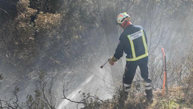 Un miembro de Protección Civil ayuda a sofocar un incendio en es Cubells.