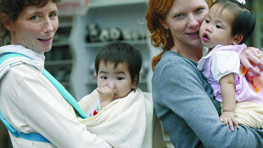 Dos mujeres con dos niñas chinas adoptadas. / reuters