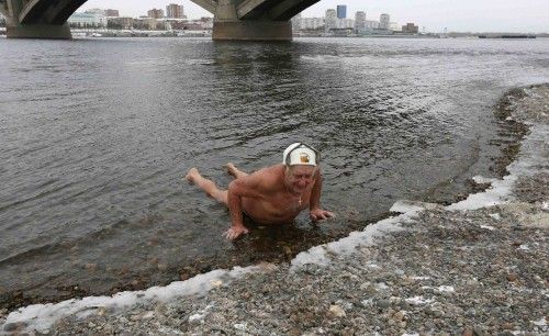 Ivan Abrosimov, de 78 años, miembro de un club de nadadores de invierno, hace flexiones en las aguas del río Yenisei a temperaturas bajo cero en la ciudad siberiana de Krasnoyarsk, 23 de noviembre de 2014.