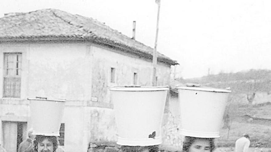 TRES MUJERES Y UNA LABOR. Una imagen de hace mas de 50 años, cuando en Las Regueras no había agua corriente y las mujeres iban con cubos a la fuente. La bibliotecaria de Las Regueras, Esther Álvarez, aporta esta fotografía, en la que aparecen, por la izquierda, Juani, de Ca Destinguiu; Bala, de Ca Sidoro, y Covadonga, de Ca Labrante.