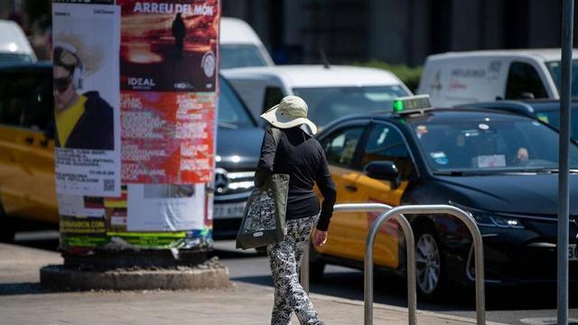 Gent caminant amb barrets per protegir-se del sol durant les jornades de calor a Barcelona.