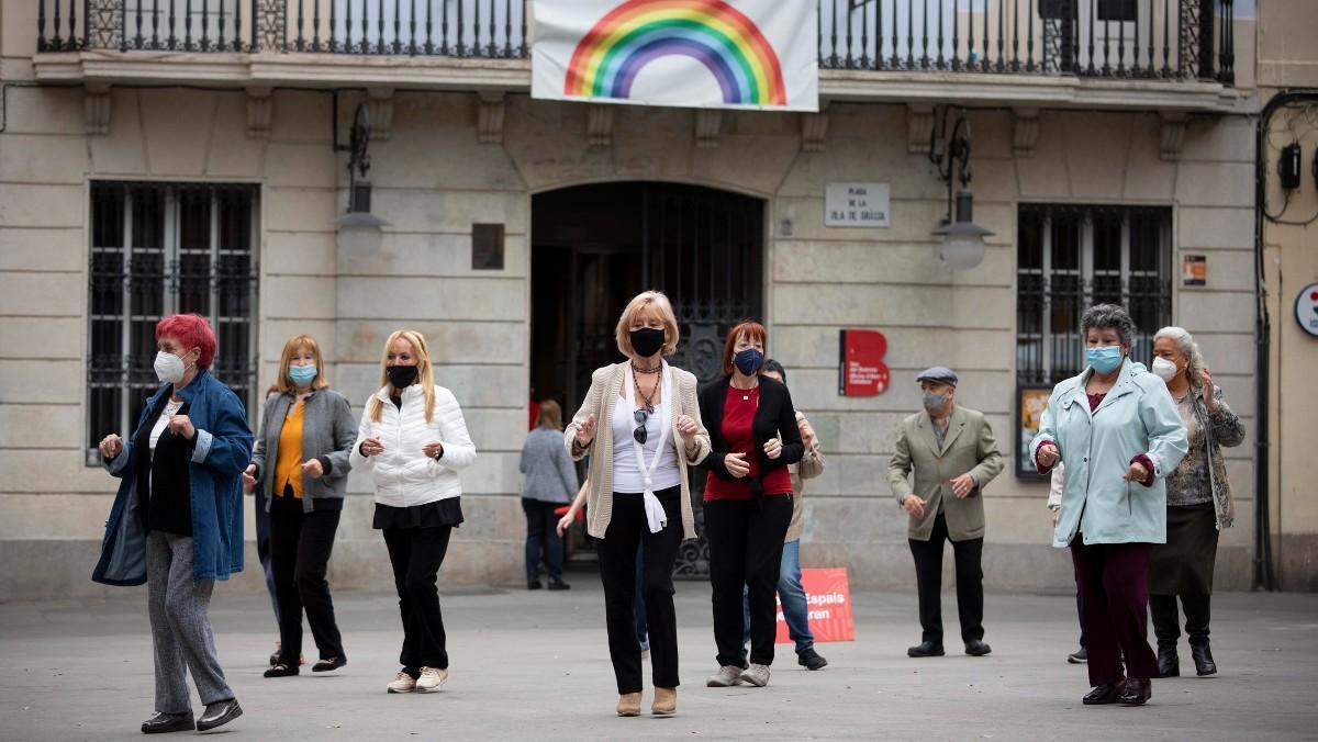 Varias personas se reúnen para una actividad al aire libre en la Vila de Gràcia, en Barcelona.