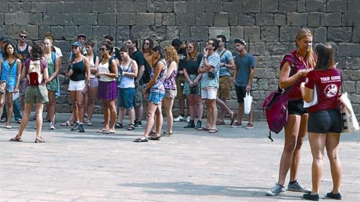 Uno de los grupos guiados gratuitos que parten de la plaza del Àngel, ayer, en plena ruta por el Gòtic.