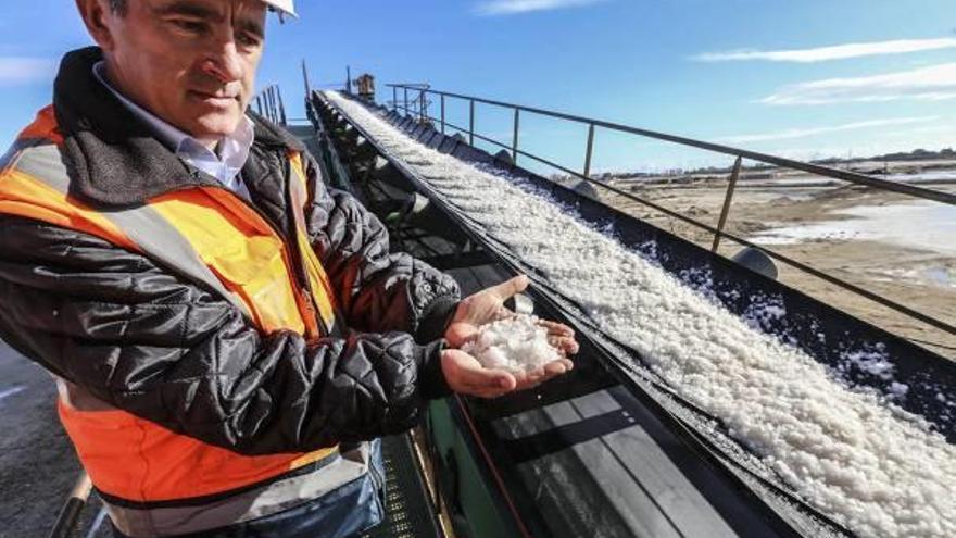 El ingeniero Joseph Pérez muestra la sal en la cinta transportadora.