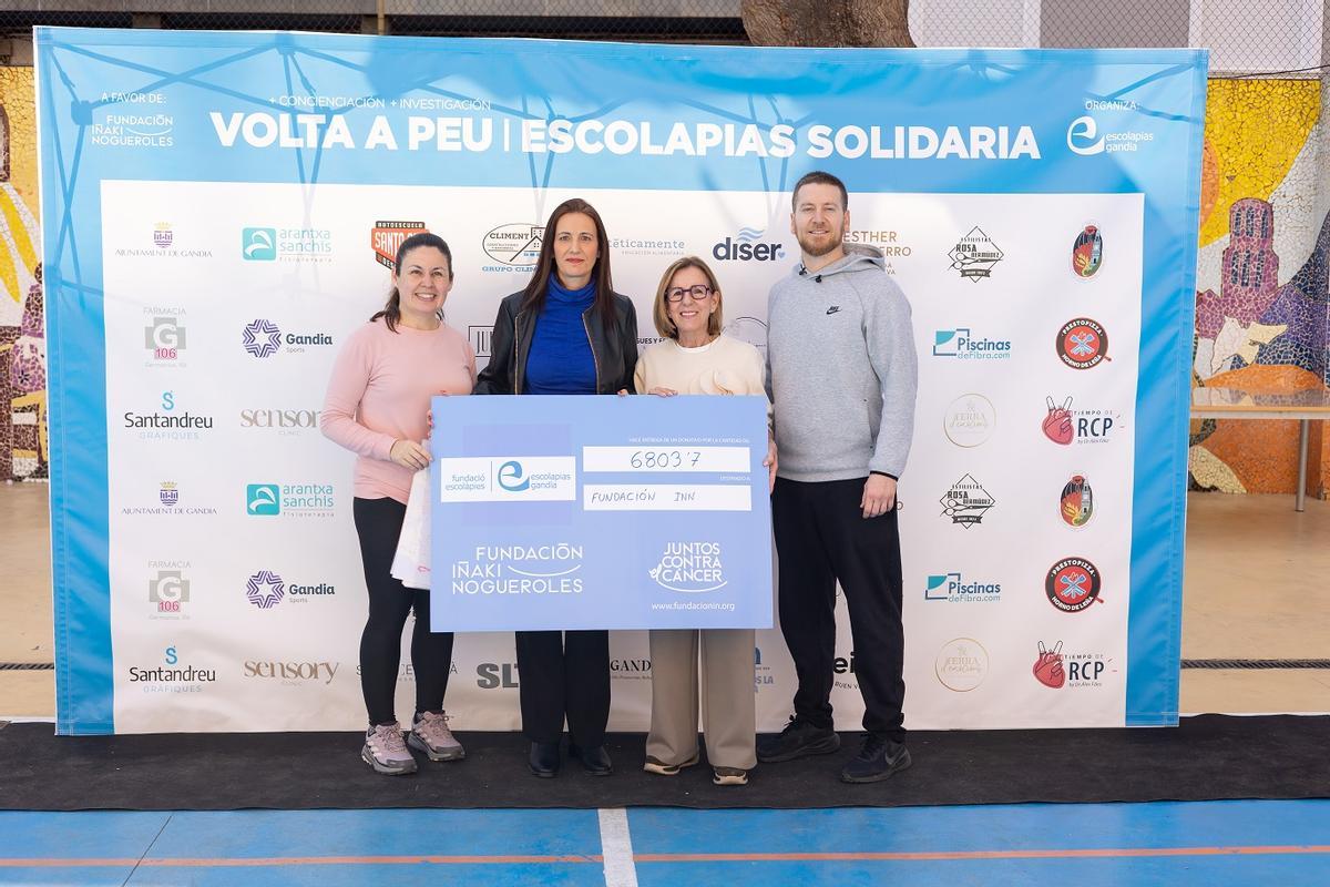 La organización posa con el talón simbólico del dinero recaudado