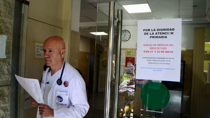 Un facultativo pasa ante de un cartel de la huelga, ayer en el centro de salud de Cangas. // G. Núñez