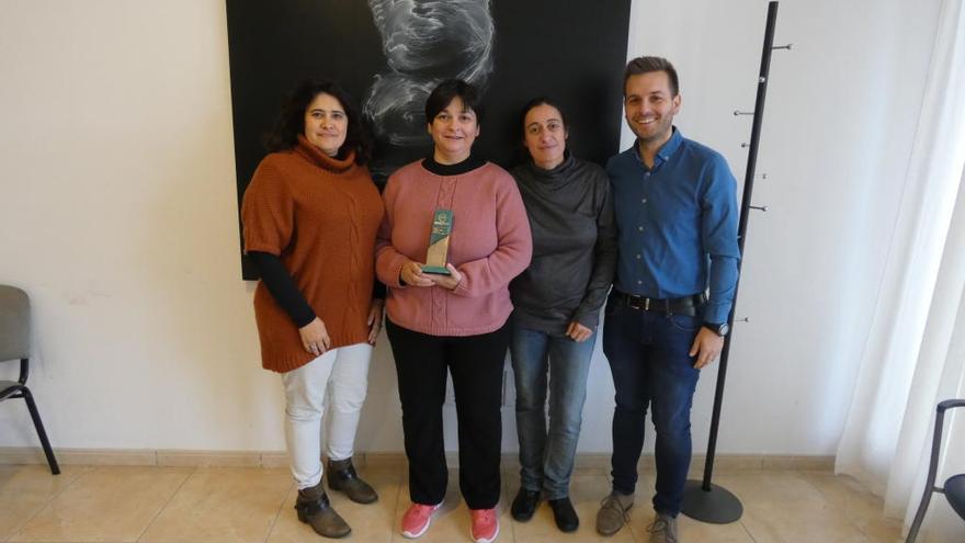 Trabajadoras sociales y autoridades municipales posan con el trofeo conseguido.