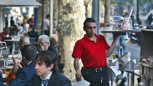 Un camarero trabajando en una terraza de un bar del Passeig de Gràcia de Barcelona, en una imagen de archivo.