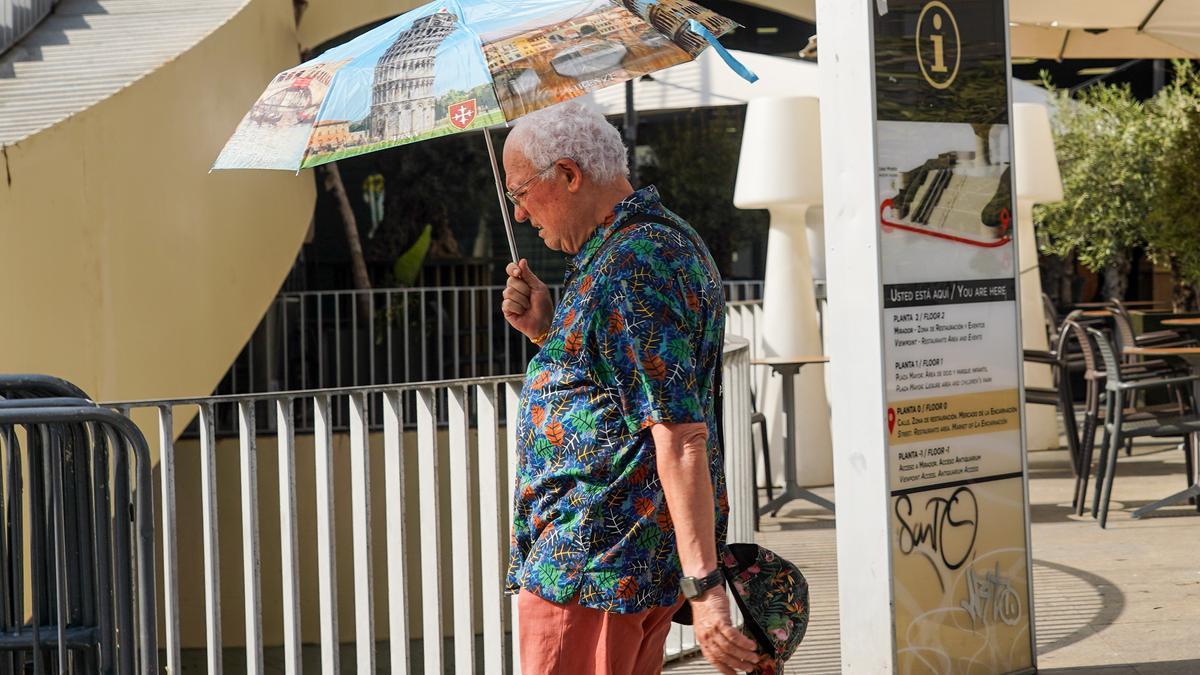 Un turista con un paraguas para reducir el calor.