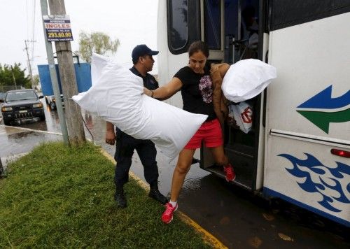A tourist, who was evacuated from her hotel arrive at the University of Puerto Vallarta used as a shelter as Hurricane Patricia approaches the Pacific beach resort of Puerto Vallarta