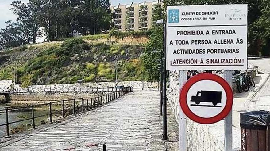 Acceso al puerto de Santa Cruz, con una cadena y un cartel de Portos criticado por su deficiente uso del gallego. L.O.