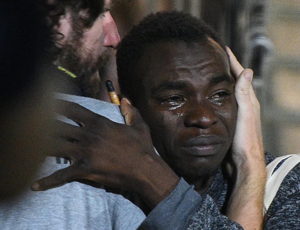 A migrant reacts as he disembarks the Spanish rescue ship Open Arms NGO, after it arrived in Lampedusa, Italy, August 20, 2019. REUTERS/Guglielmo Mangiapane