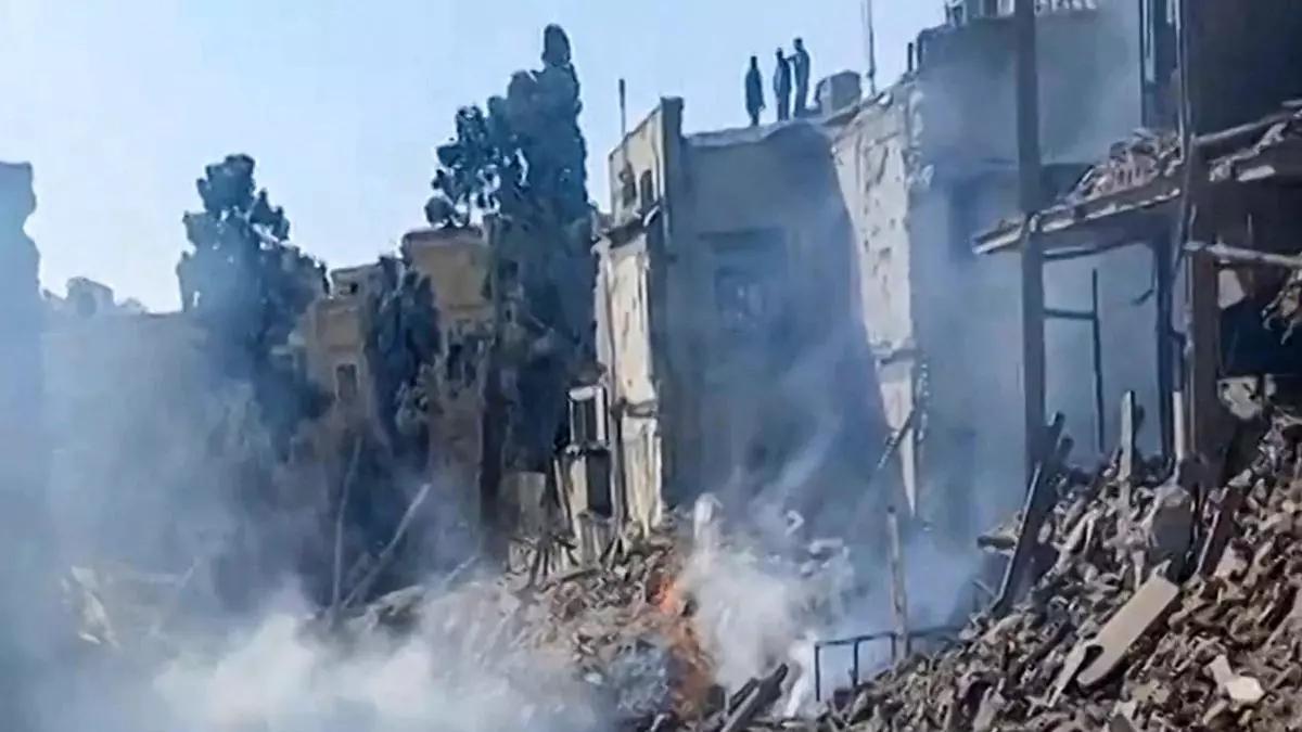 Imágenes UGC publicadas en redes sociales el 28 de febrero de 2026 y verificadas por equipos de AFPTV en París, muestra a personas inspeccionando los daños en el lugar del impacto tras los ataques estadounidenses e israelíes contra Teherán.