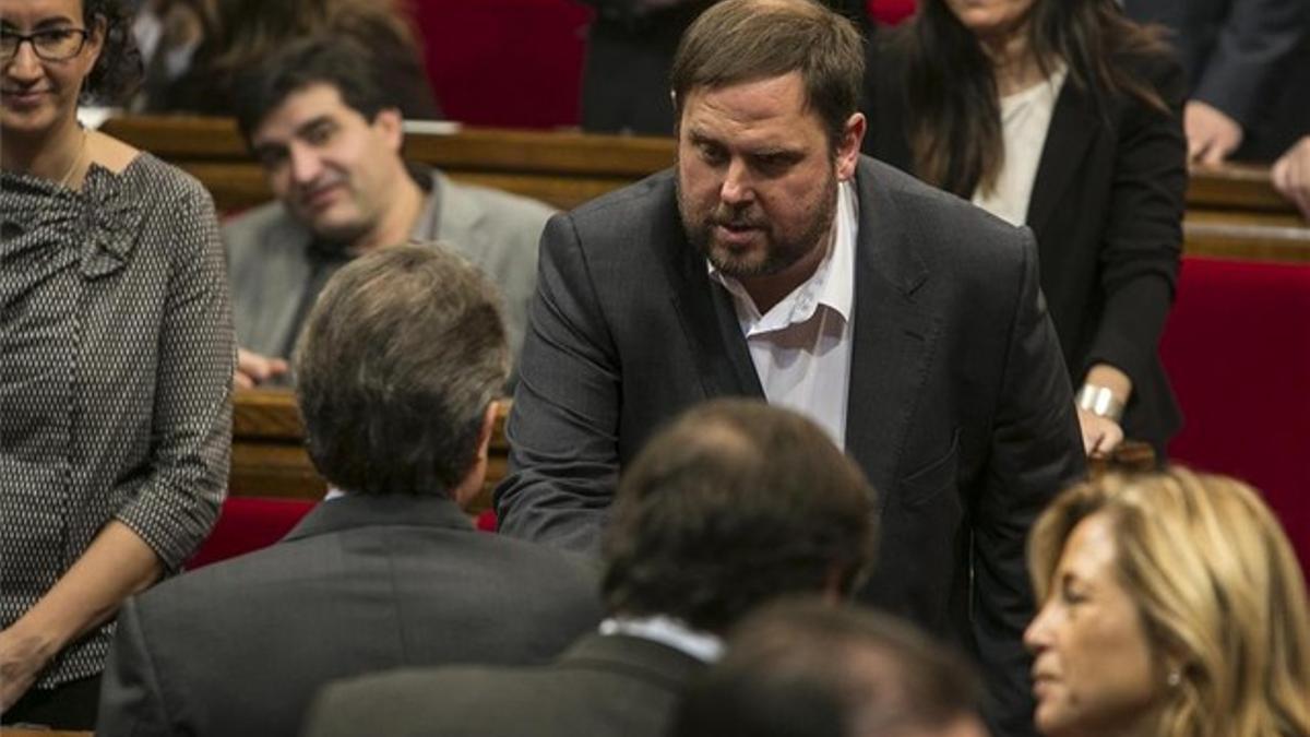 Artur Mas y Oriol Junqueras se saludan durante el pleno de constitución del Parlament.