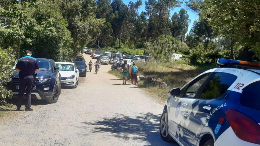 Agentes de la Policía Local denunciando por coches aparcados en el entorno de las playas. |   // SANTOS ÁLVAREZ