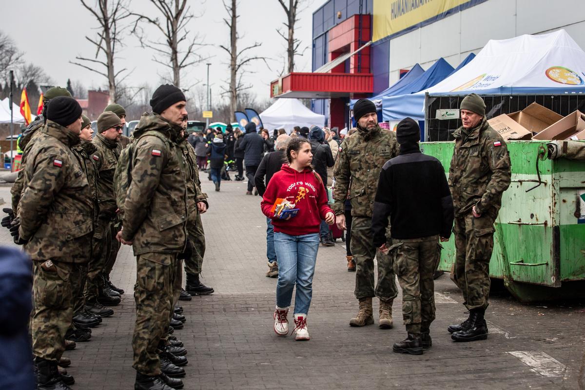 Soldados polacos ayudan a personas procedentes de Ucrania, en el centro de acogida temporal de Przemysl, en Polonia.