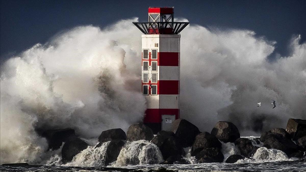 Olas de gran altura rompen contra el faro de Ijmuiden  en la costa del Mar del Norte en Holanda durante la primera tormenta del año.