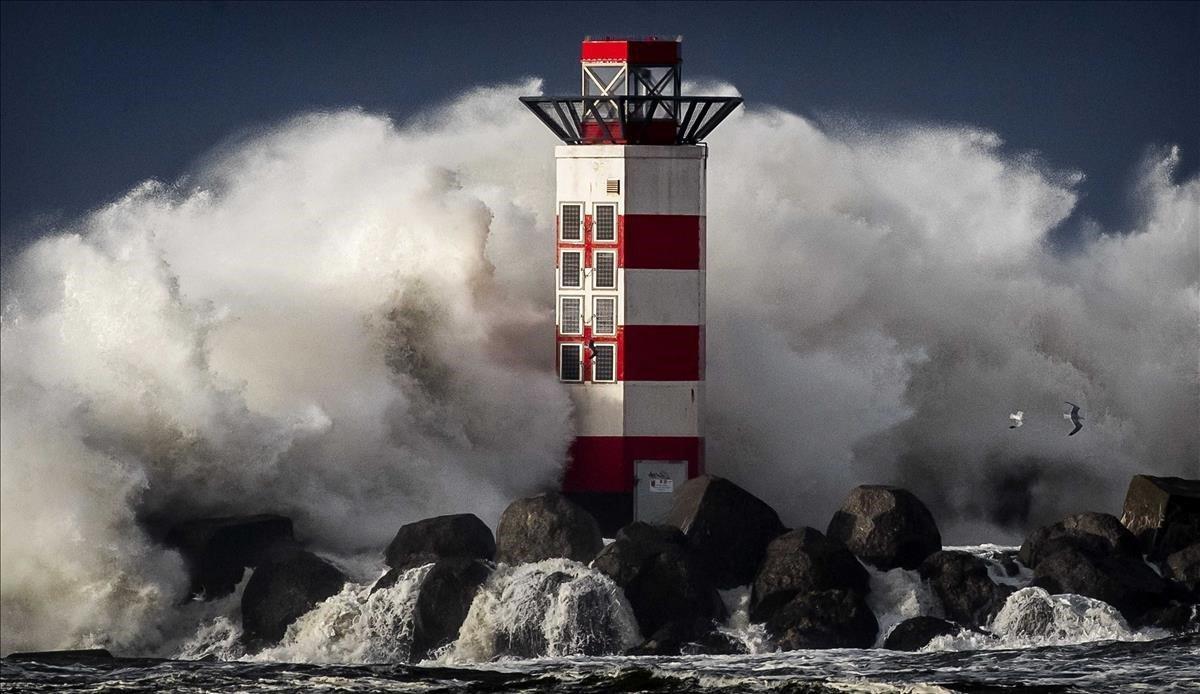 Olas de gran altura rompen contra el faro de Ijmuiden  en la costa del Mar del Norte en Holanda durante la primera tormenta del año.