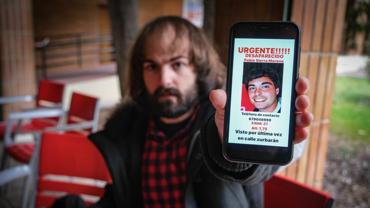 Un alumno de la UEx enseña en su teléfono móvil uno de los carteles sobre Pablo Sierra que le ha llegado por WhatsApp.