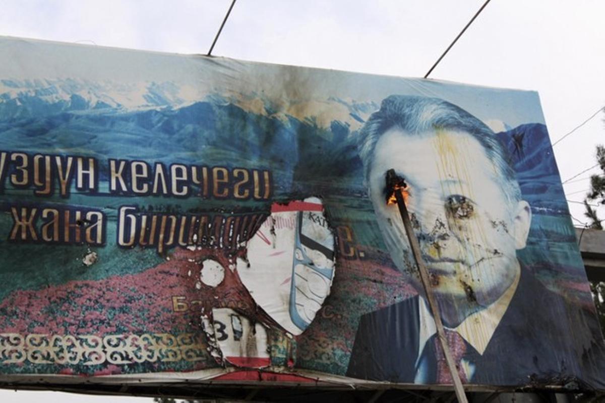 Opposition supporters burn a billboard displaying Kyrgyz President Kurmanbek Bakíev during a ral·li in the northwestern town of Tales