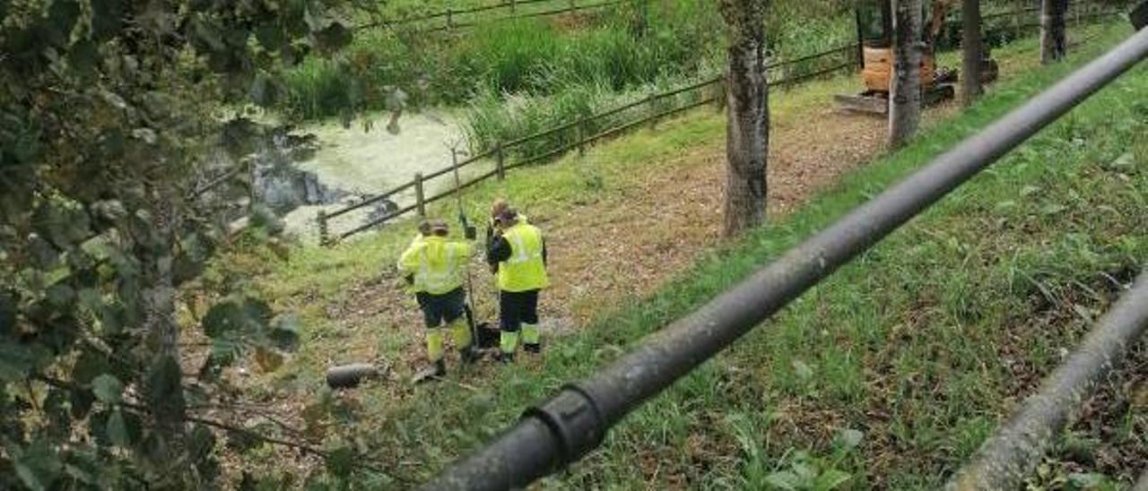 Operarios de Espina y Delfín, ayer, realizan obras en un pozo en el Paseo do Pontiñas. |