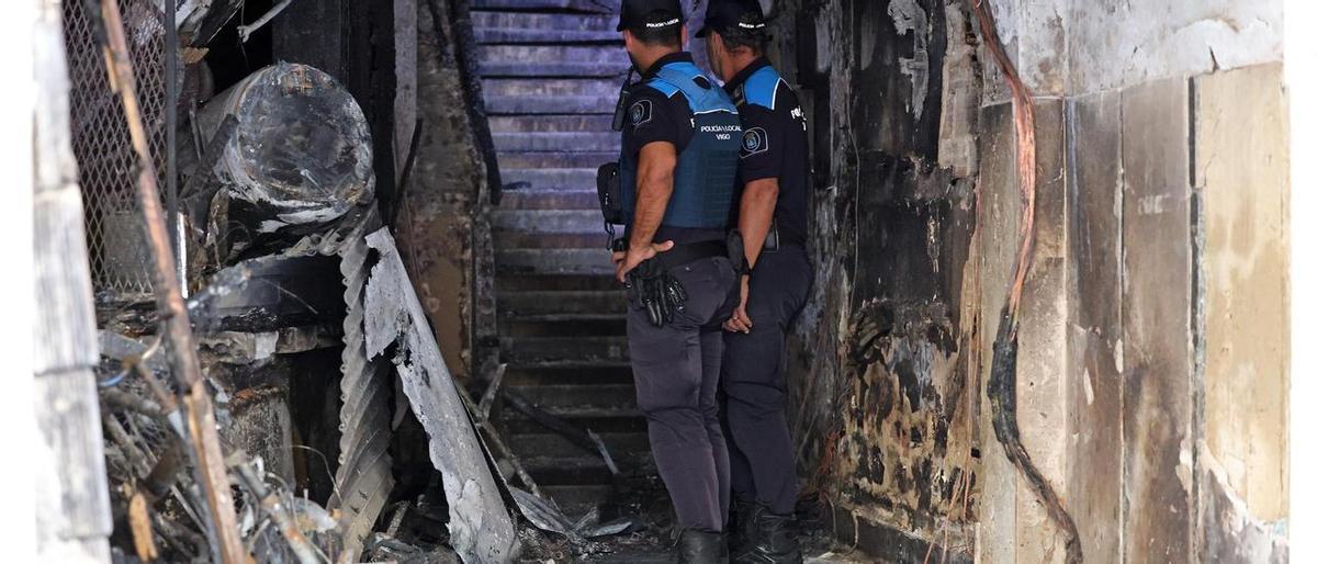 Dos agentes en el portal del edificio incendiado en la calle Alfonso