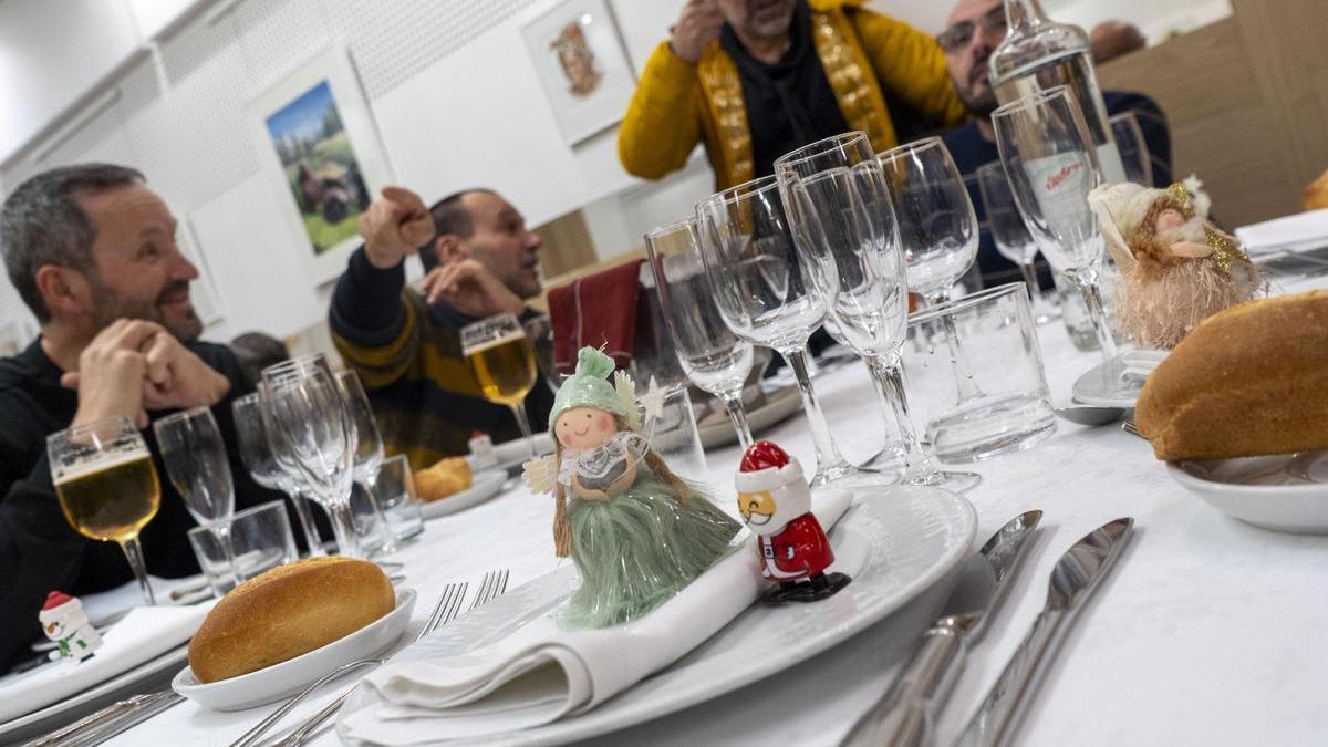 Diversos comensals a taula a punt de fer un àpat de Nadal