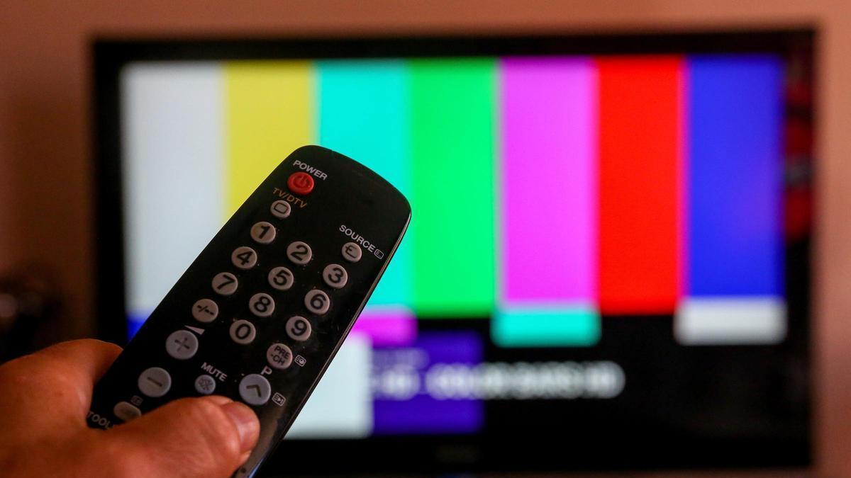 Una persona sintoniza los canales de una televisión, en una foto de archivo.