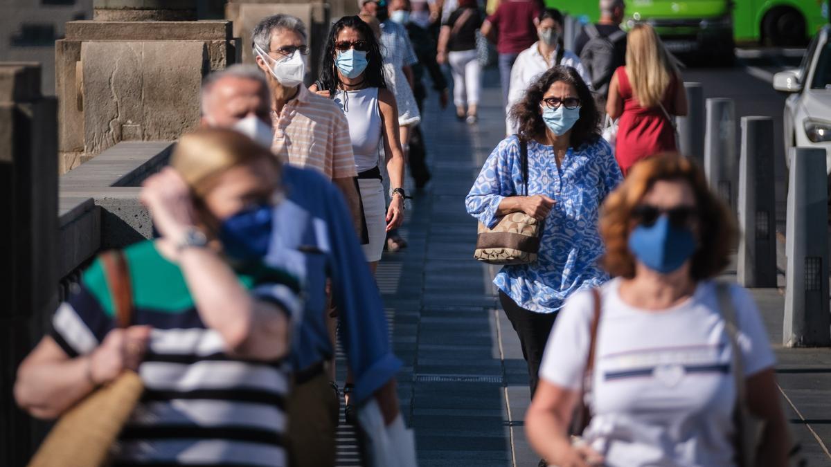 Varias personas con mascarilla caminan por Santa Cruz de Tenerife.