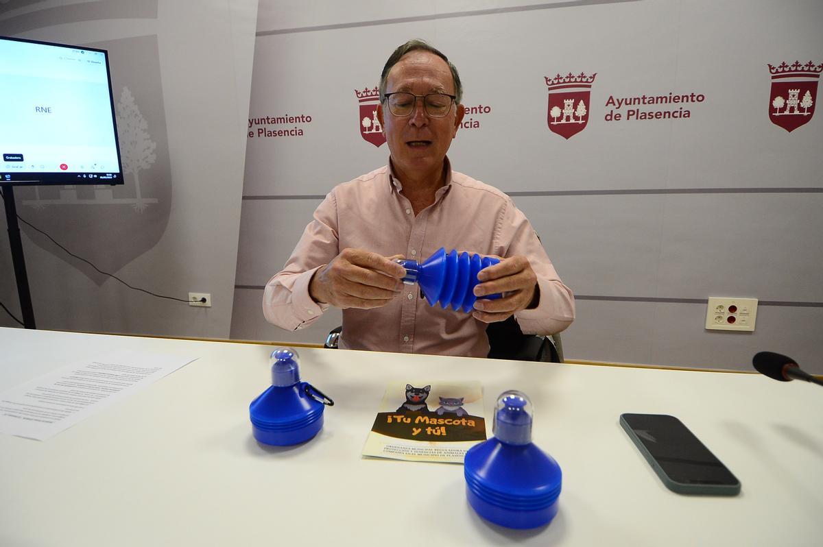 El concejal muestra las botellas que se repartirán para diluir los orines.