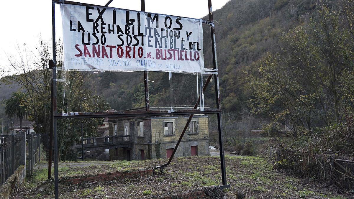 Una pancarta de protesta, con el edificio de la botica justo detrás. | Jandro Rodríguez