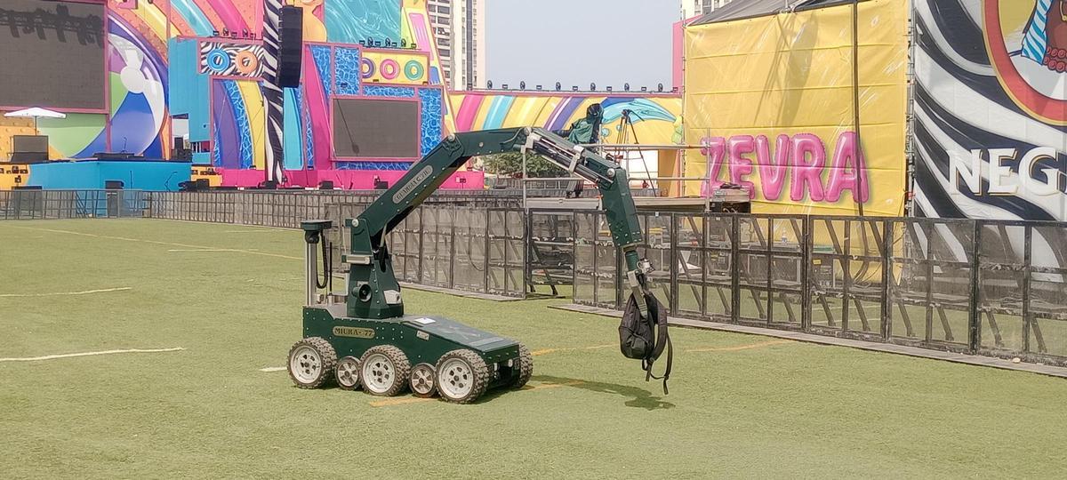 Un robot traslada la mochila con explosivo detectada por un perro durante el ensayo.