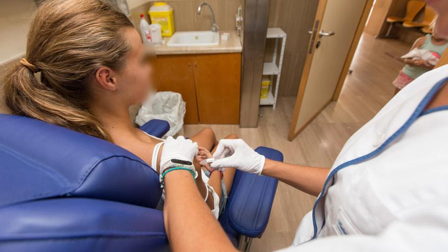 Una enfermera aplica una vacuna a una joven.